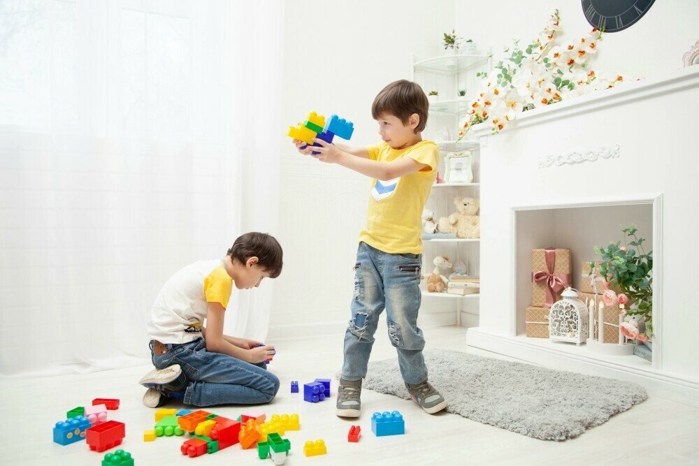 two boys playing with large lego block toys