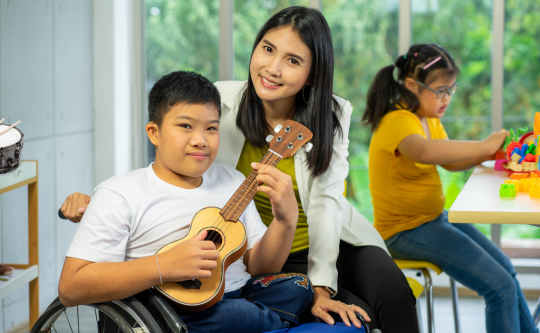 children with diverse abilities playing with toys and a guitar 