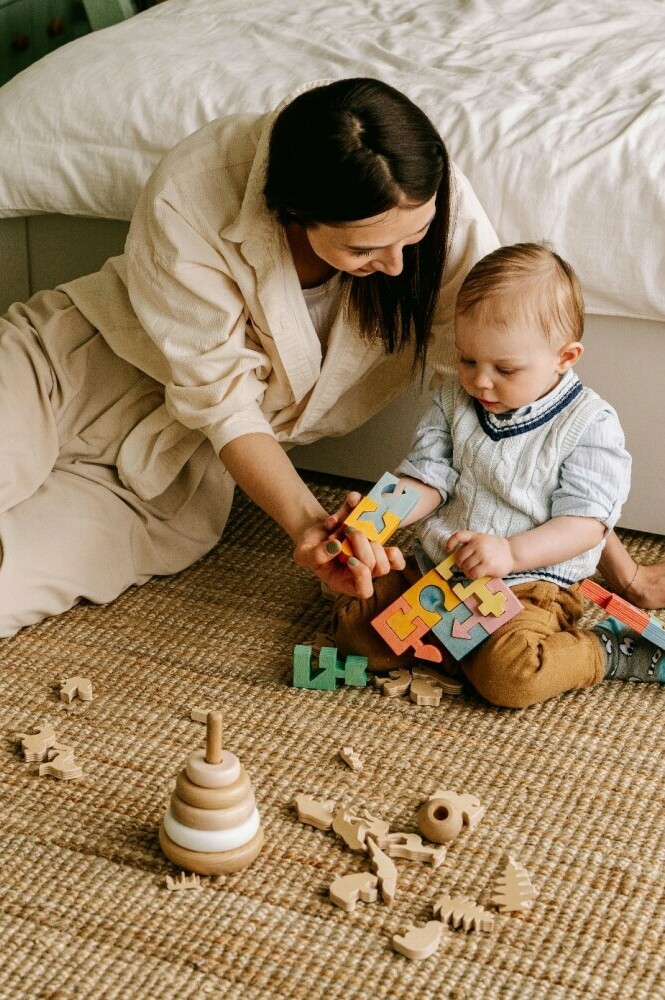 a Mom with her toddler learning how to play with wooden blocks and wooden puzzles.